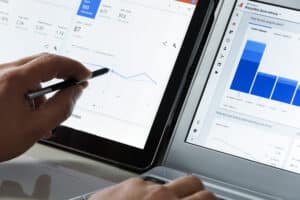 An analyst looking at website traffic and user data between two computer screens
