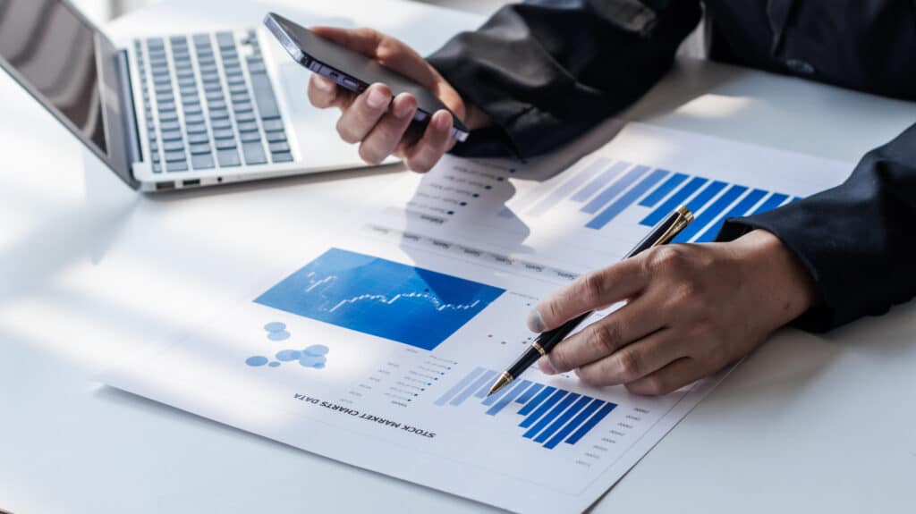 An analyst looking at a computer screen and crunching search data or any data with graphs before a big acquisition.