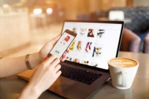 a hand holding a phone as it pays for shoes online
